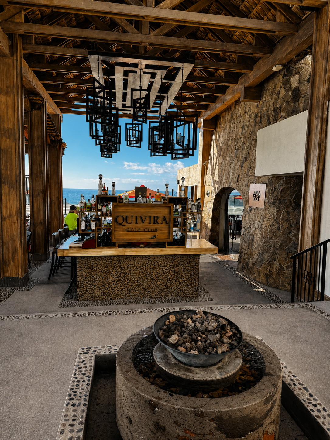 Quivira Golf Club open-air bar in Cabo with wood beams, stone accents and an ocean view beyond